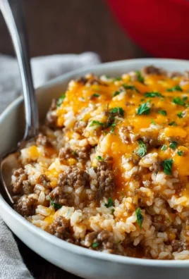 Cheesy ground beef and rice casserole in a baking dish, topped with melted cheese
