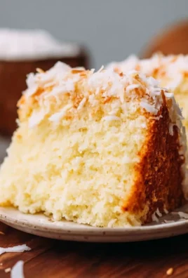 Delicious coconut cake topped with fresh coconut flakes and creamy frosting