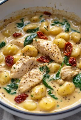 Creamy chicken and gnocchi dish garnished with herbs