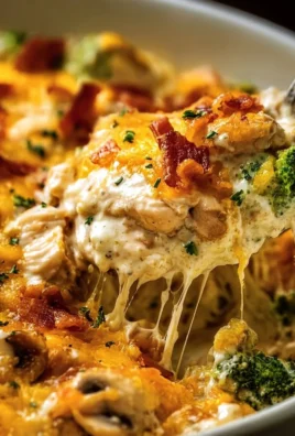 Creamy low carb chicken casserole served in a dish topped with cheese and herbs.