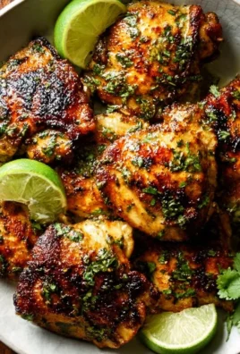 Crispy cilantro lime chicken thighs served with fresh herbs and lime wedges