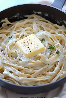 A delicious plate of creamy Fettuccine Alfredo topped with parsley.