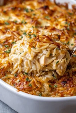 French Onion Chicken Orzo Casserole topped with melted cheese and herbs