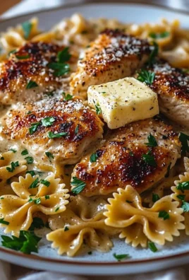 Garlic Butter Chicken served with bowtie pasta on a plate.