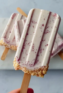 Refreshing Greek yogurt popsicles in colorful molds on a sunny day