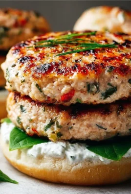 Juicy Greek chicken burger topped with fresh tzatziki sauce on a plate