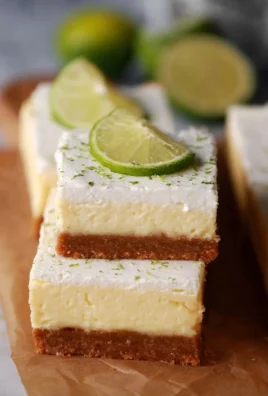 Delicious Key Lime Pie Bars topped with whipped cream and lime zest