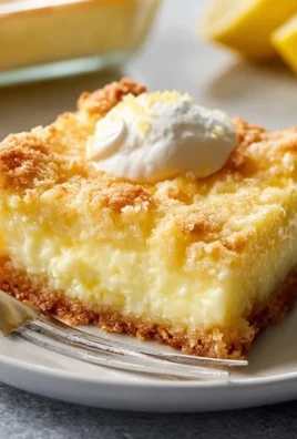 Sliced Lemon Cream Cheese Dump Cake on a plate with a lemon slice decoration.