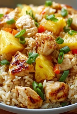Plate of pineapple chicken served with rice, garnished with green onions