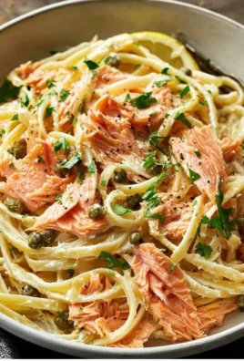 Delicious smoked salmon linguine served in a bowl with herbs.