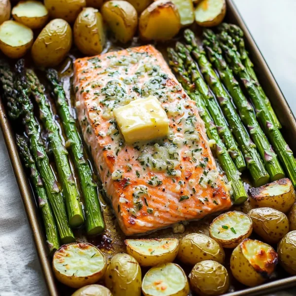 Sheet pan garlic butter salmon served with roasted potatoes and asparagus.