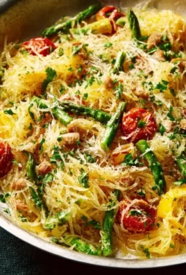 A bowl of spring spaghetti squash served with fresh herbs and vegetables.