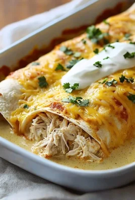 Delicious white rotisserie chicken enchiladas topped with cheese and herbs