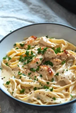 Creamy chicken Alfredo pasta dish garnished with parsley