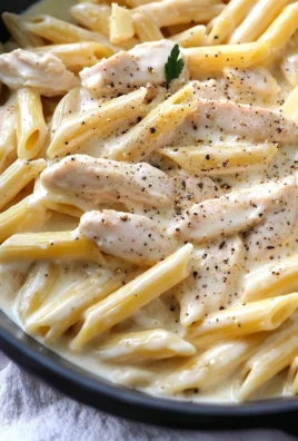 Creamy chicken alfredo pasta served with herbs and parmesan cheese