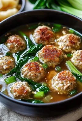 Comforting ginger chicken meatball soup with bok choy in a bowl