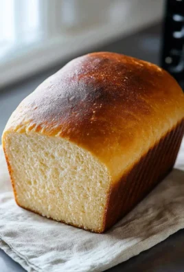 Freshly baked homemade bread loaf on a wooden cutting board.