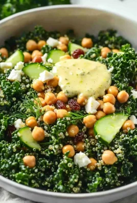 A colorful kale quinoa salad topped with fresh vegetables and lemon dressing