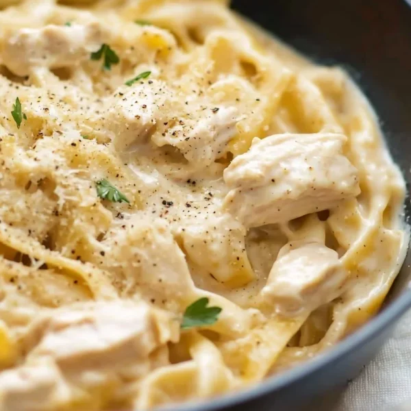 Creamy chicken Alfredo served with fettuccine and garnished with parsley